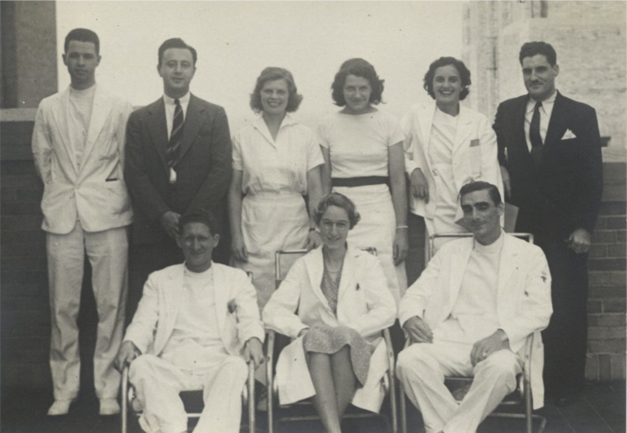 A black and white photo of 9 doctors, Apgar included pose for a photo.