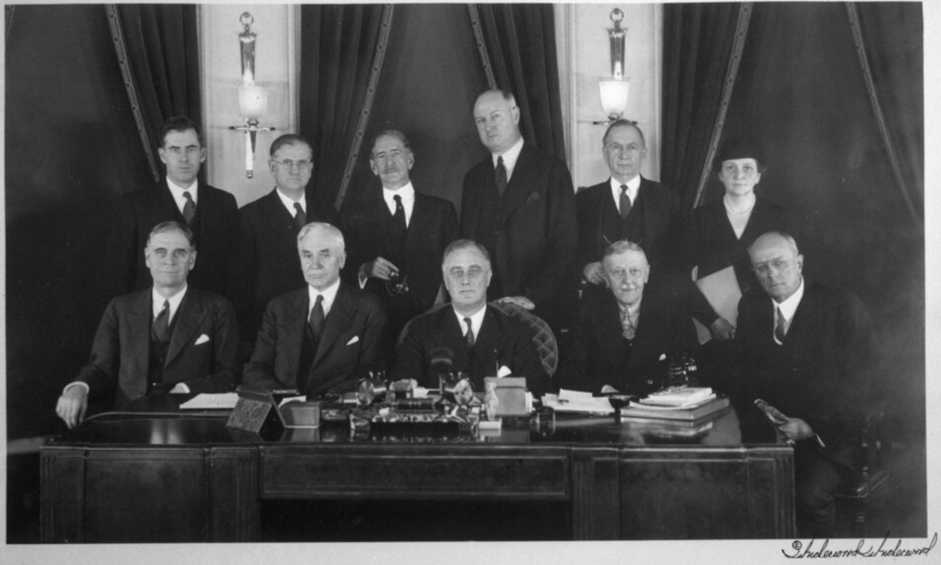 Black and white photo of President Roosevelt and his cabinet in taken in an office