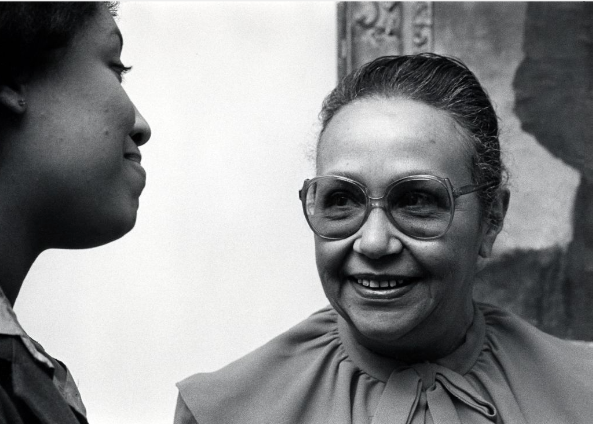 Black & white photo of Cooke Wright smiling towards a colleague.