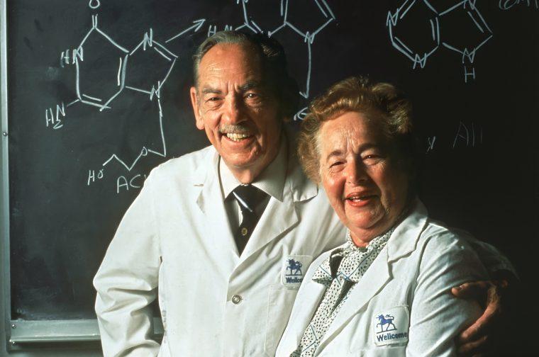 Elion and Hitchings posing in front of a chalkboard.