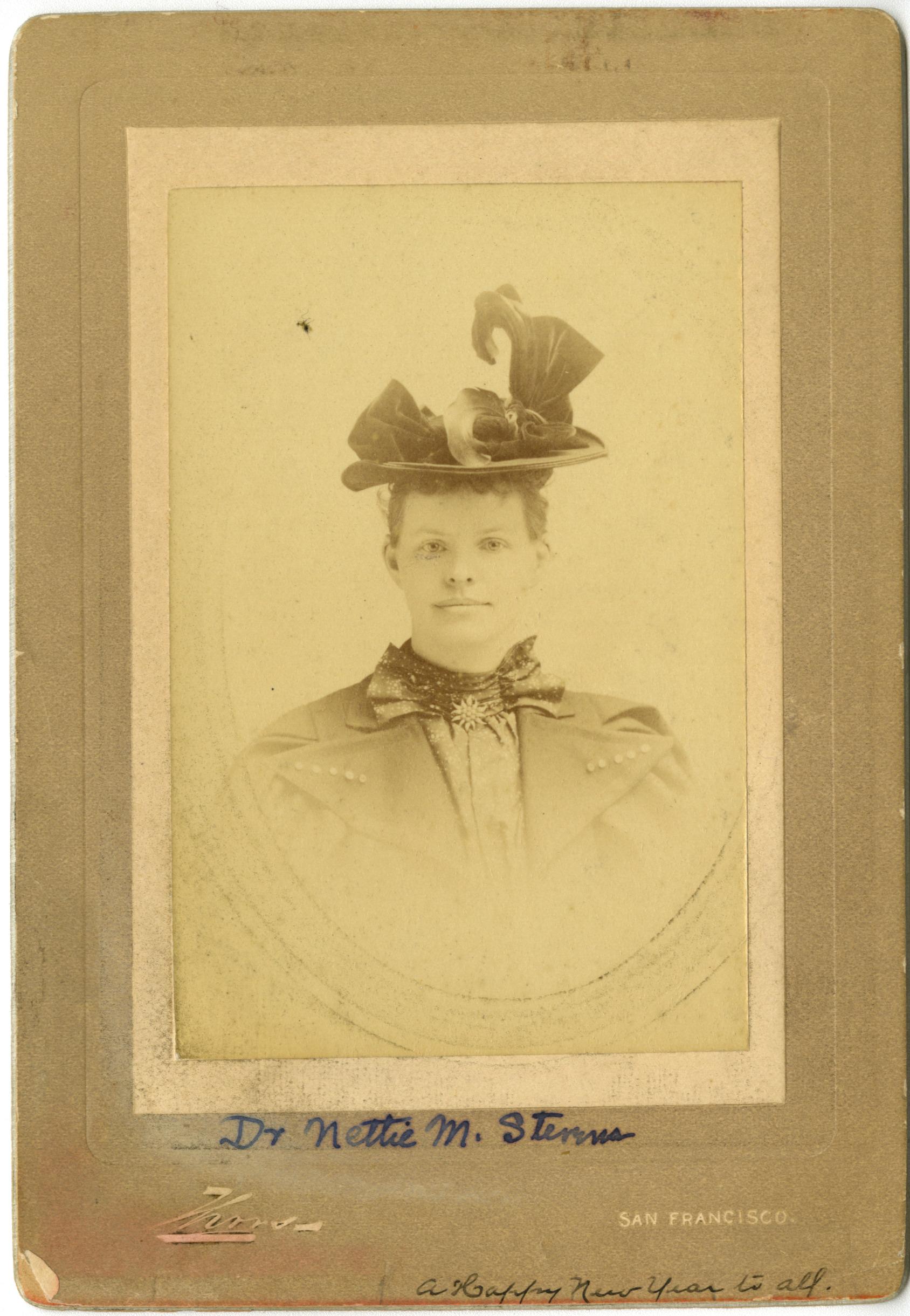 Aged portrait of Nettie Stevens wearing a decorative hat and coat. 