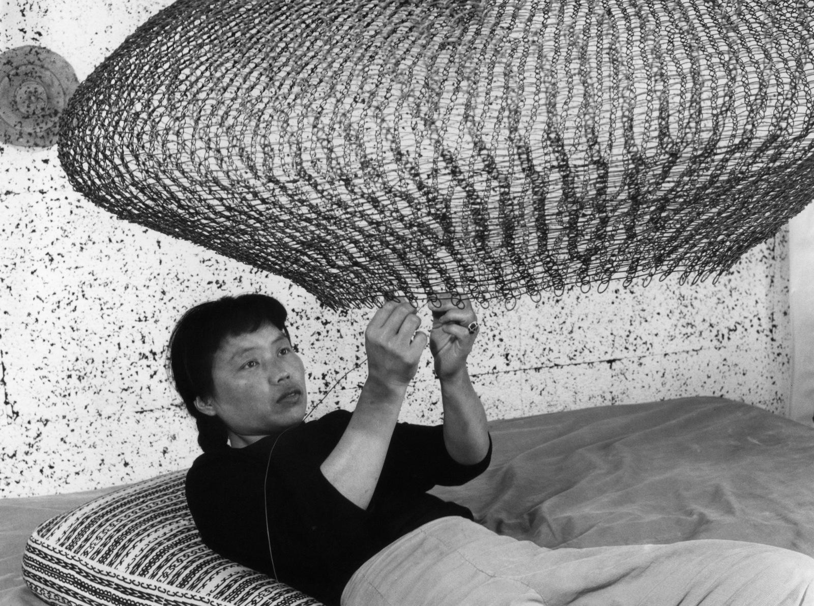 Ruth Asawa works on a wire sculpture in her studio