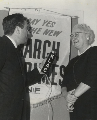 Apgar speaks into a mic held by a journalist.
