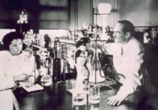 Black and white photo of Elion and Hitchings working in an laboratory.