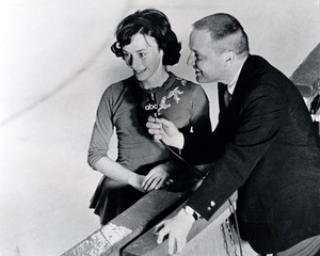 Photo of Peggy Fleming being interviewed by a news reporter while on the ice.