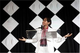 Kihana Wilson Stands at Clear Podium Giving Speech