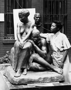 Augusta Savage posing with her sculpture.