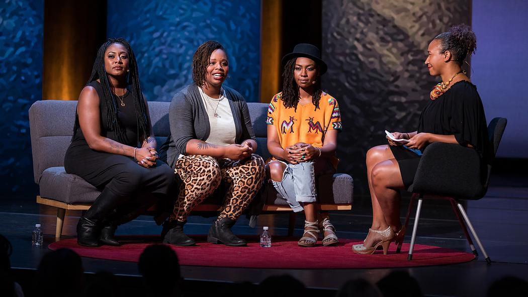 Alicia Garza, Patrisse Cullors, and Opal Tometi sit together on a couch while being interviewed by Mia Birdsong.