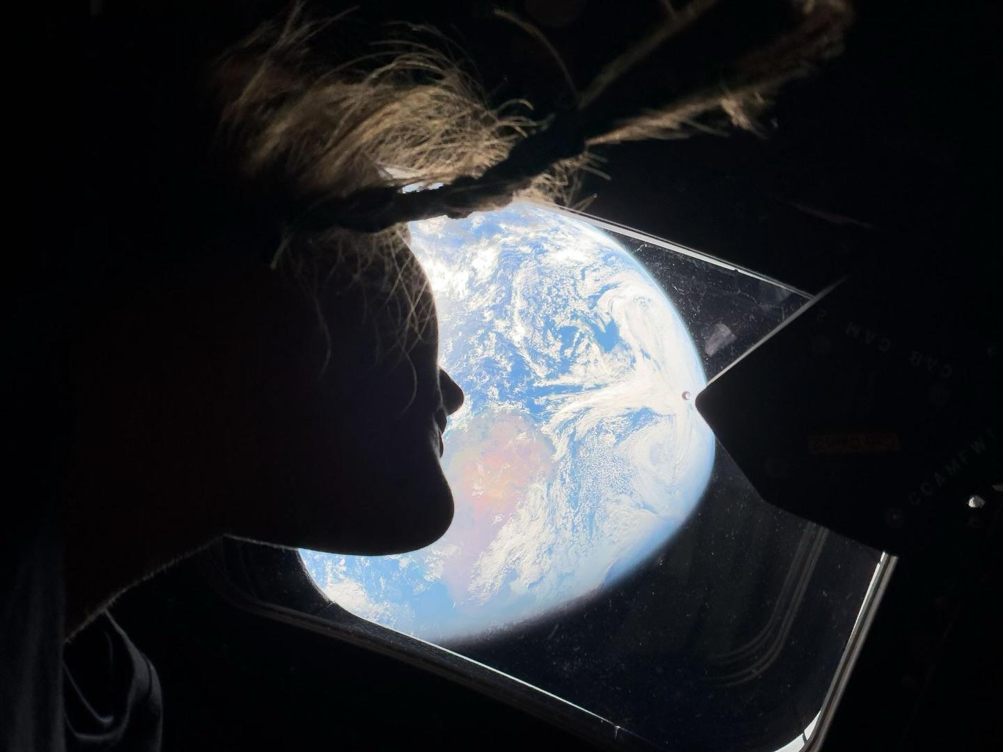 Image of the profile of Christina Koch in space, overlooking earth with a braid dangling in frame. Courtesy of Christina Koch’s official Instagram account.