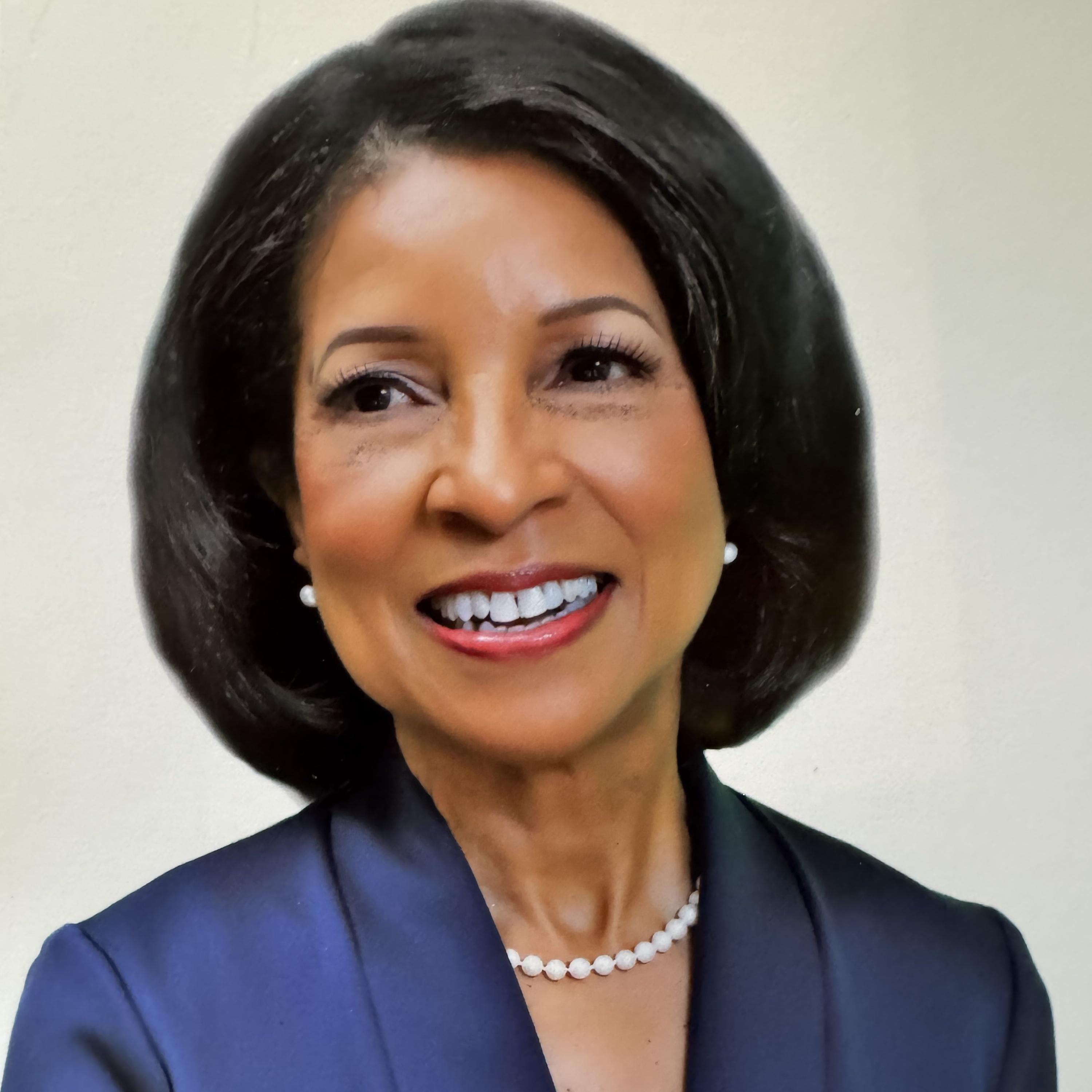 Deborah Brittain in a blue jacket, smiling.